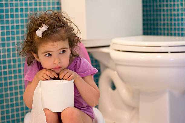 Little girl at potty training age sitting on a toilet